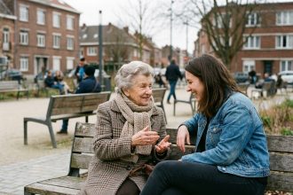 Femme âgée souriante avec femme plus jeune dans un parc à Roubaix