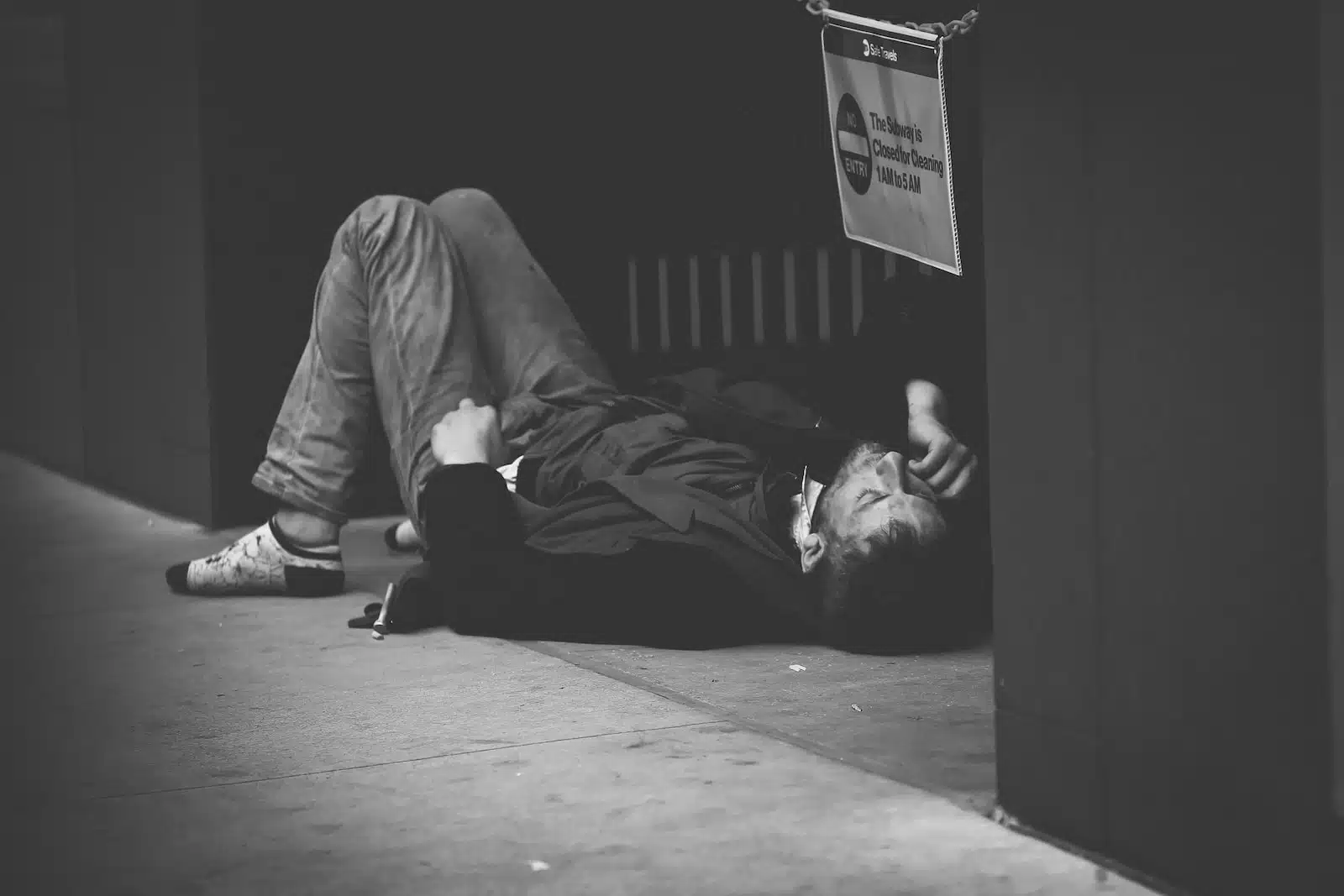 man lying on floor in grayscale photography